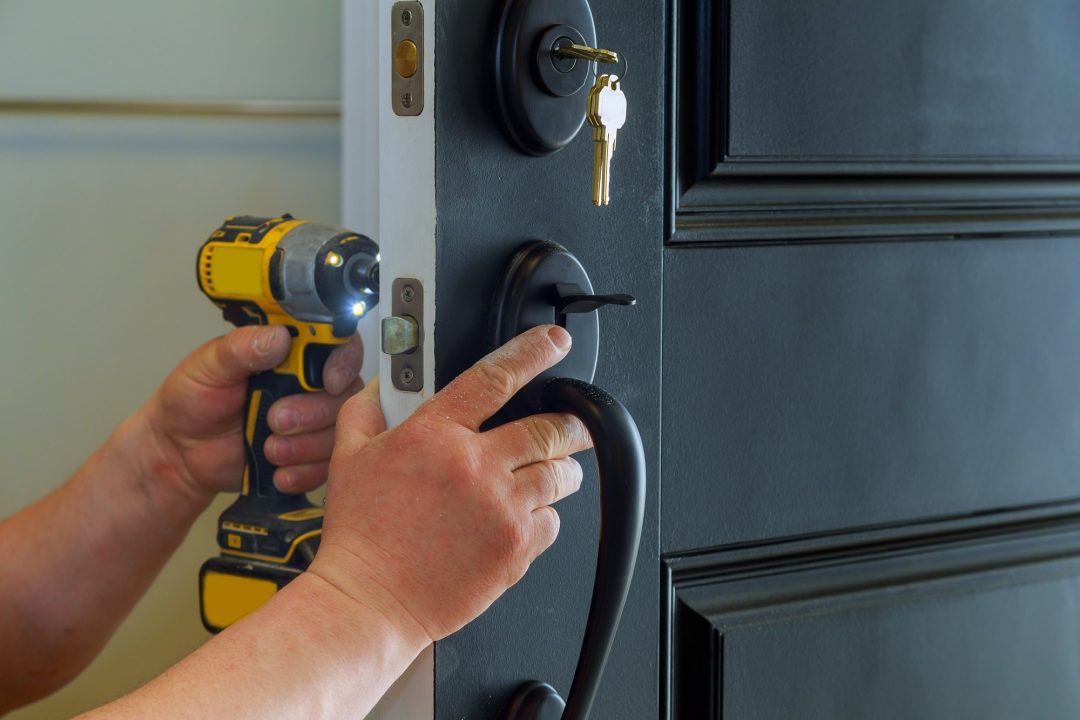 Locksmith installing a door lock in a residential home in London, Hertfordshire, Essex